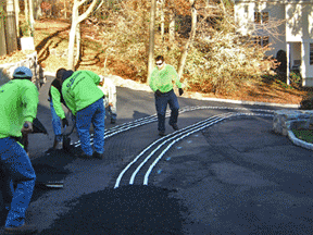 An asphalt driveway being retrofitted with a radiant snow melting system.